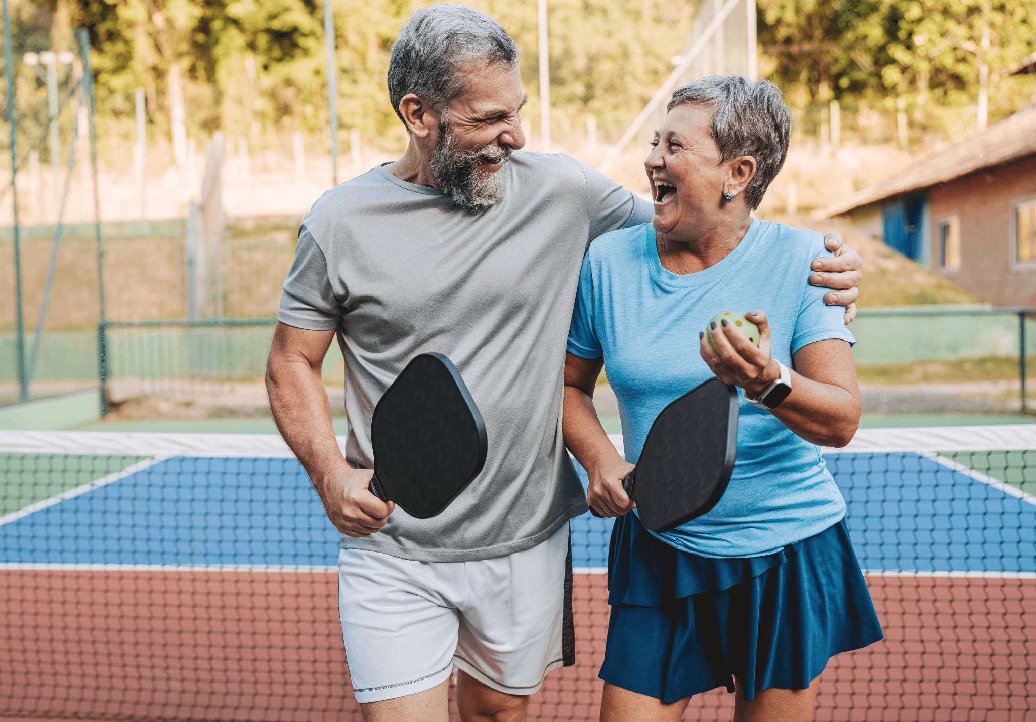 GettyImages-1080225792-e1741803468383-2048x1427 A man and woman holding rackets on top of a tennis court.